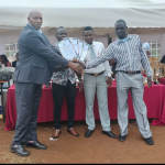 county director of education(Mr Kigaya) awarding teachers.